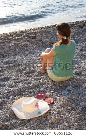 The girl, hat and flip-flops on the stones outdoors shooting
