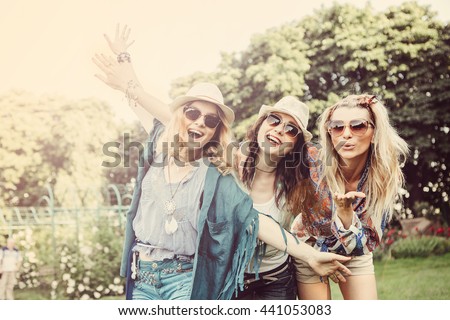 Happy friends in the park on a sunny day . Summer lifestyle portrait of three hipster women  enjoy nice day, wearing bright sunglasses. Best friends girls having fun, joy. Lifestyle