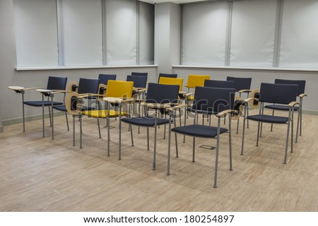 Empty bright lecture hall with chairs. Grey black yellow tones