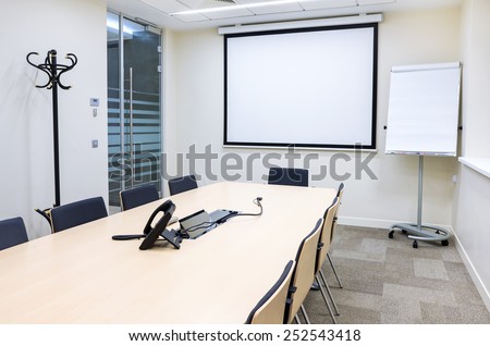 Empty small bright meeting room with TV proektor screen and flipchart. Modern design