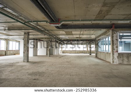 Unfinished interior of business center under construction in grey colours. Lift shaft