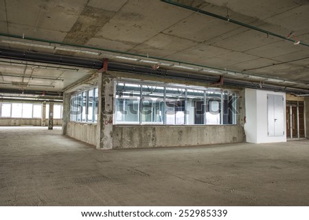 Unfinished interior of business center under construction in grey colours. Lift shaft