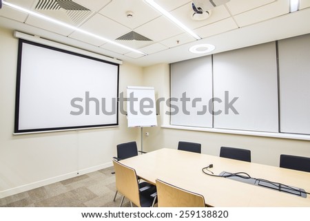 Small empty meeting room with TV projector and flipchart
