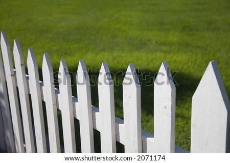 White picket fence with green grass background