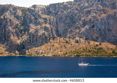 A small yacht in front of huge mountain. Aegean sea, Turkey.