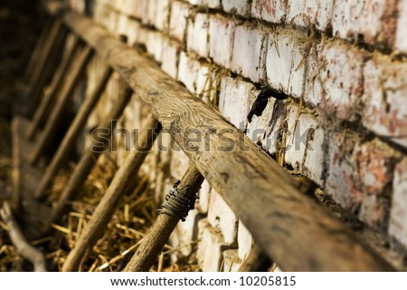 Old ladders laying on brick wall in haystack, shallow DOF