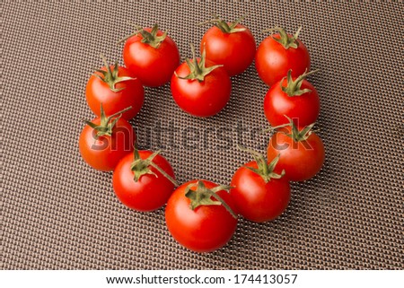tomatoes heart on nice brown textured background