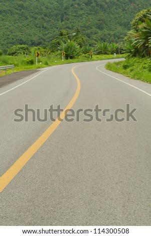 Curve road beside mountain.