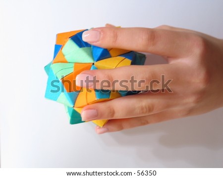 a hand holding a geormetric figure