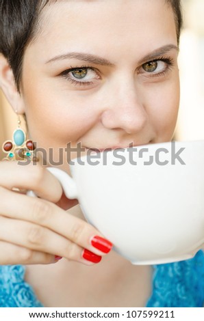 Young woman at home sipping tea from a cup