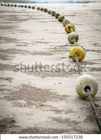 Old buoys with rope on the beach