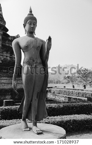 Ancient Buddha image at Sukhothai historical park, Thailand (black and white with grain effect)