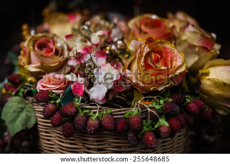 Artificial flowers in the basket over black background