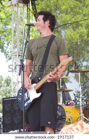 Gabe Watts, lead guitar player for Olivia The Band, performs at on outdoor concert