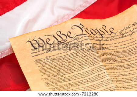U.S. Constitution with red and white stripes flag background.