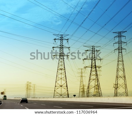 high voltage post.High-voltage tower sky background,besides the highway.