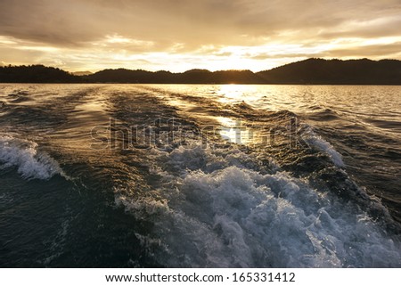 Churning  water in the ocean shows lots of turbulence and splash.sunset, Good for background image.