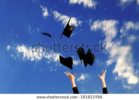 Student with congratulations throwing graduation hats in the air celebrating