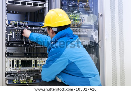 Man connecting network cables to switches