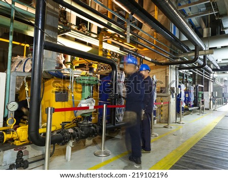 maintenance engineers checking technical data of heating system equipment in a boiler room