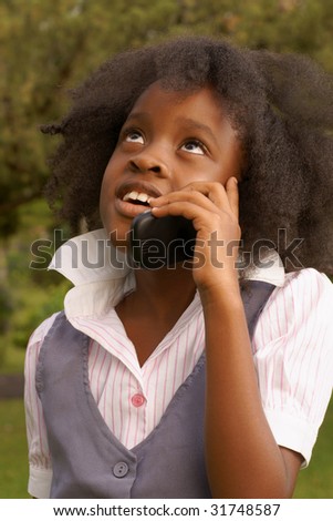 young afro caribbean girl talking on cell phone in park