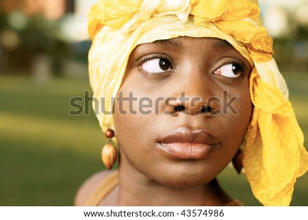 beautiful woman with golden head scarf with strong side look