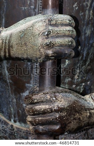 stone statue hands holding pole