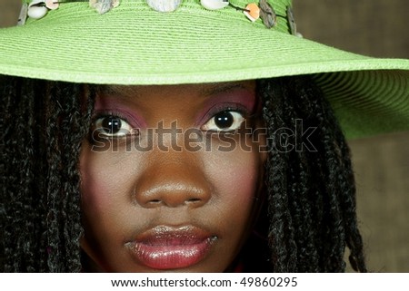 woman with green floppy hat looking at you intensely