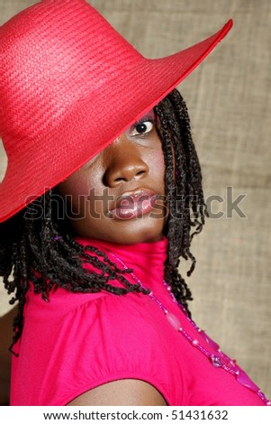 woman with red floppy hat looking at you with one eye visible