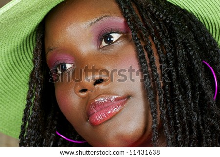 woman with green floppy hat looking away to her side