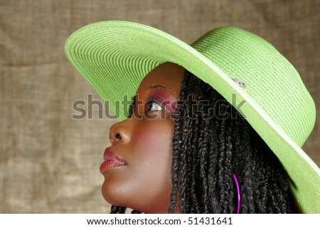profile of a woman with green floppy hat looking up