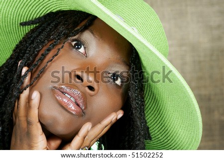 woman with green floppy hat looking at you intensely