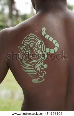 green tiger painted on the back of an african descendant man
