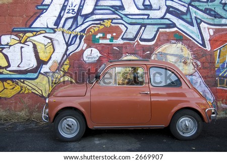 iconic italian small red car against contemporary graffiti background rome italy