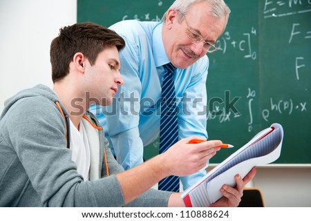 male student with a teacher in classroom