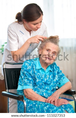 Nurse dressing the hair of a senior woman