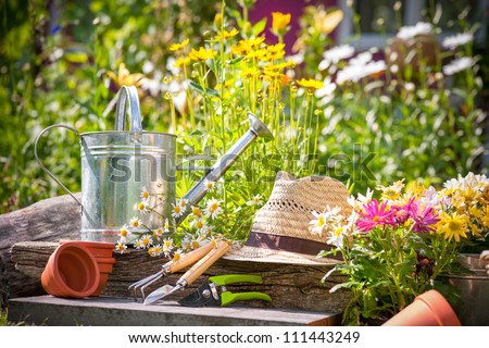 Gardening Tools And A Straw Hat On The Grass In The Garden