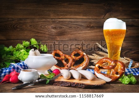 Bavarian sausages with pretzels, sweet mustard and beer on rustic wooden table. Oktoberfest menu