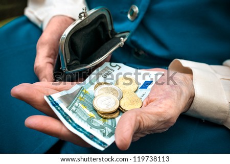 elderly caucasian woman counting money in her hands