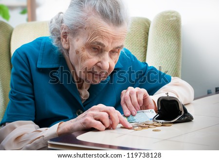 elderly caucasian woman counting money  on table