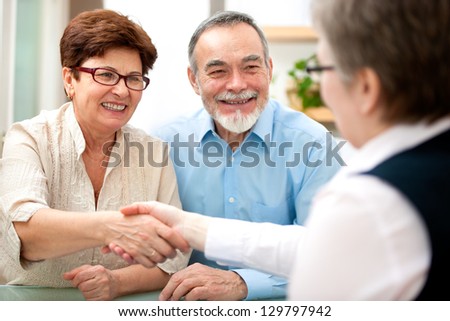 Senior Couple Smiling While Shaking Hand With Financial Advisor