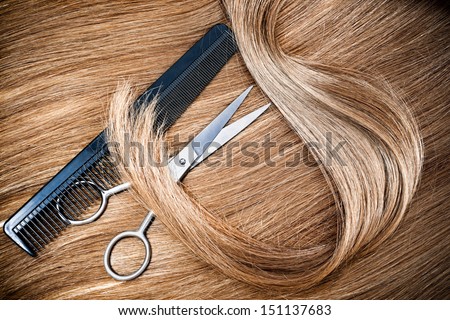 professional hairdresser scissors and comb on hair background