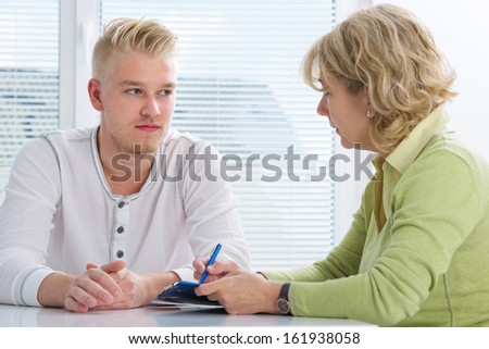 Teenager having a  therapy session while therapist is taking notes