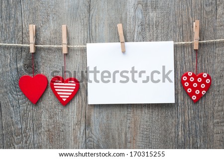 Message and red hearts on the clothesline against wooden background