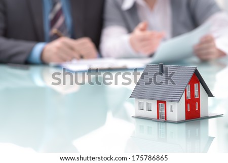Businessman Signs Contract Behind Home Architectural Model