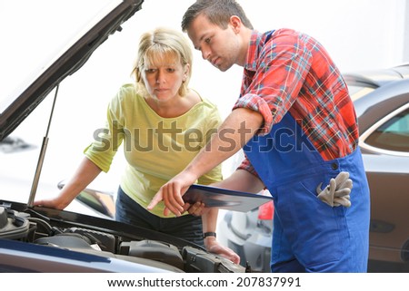 Auto mechanic and female customer in auto repair shop