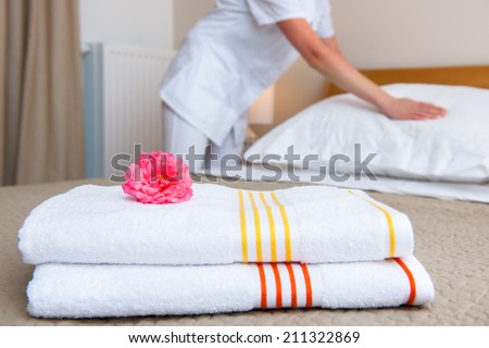 Hotel room service. Young maid changing bedclothes in a room