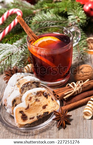 Glass of red mulled wine on table with candy and christmas decorations