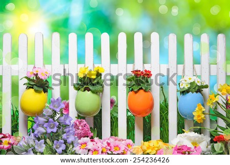 Easter eggs on fence with spring flowers
