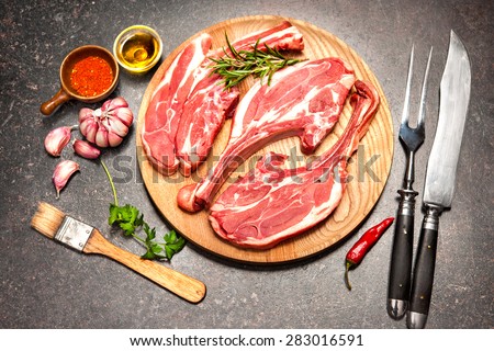 Racks of lamb ready for cooking on dark background
